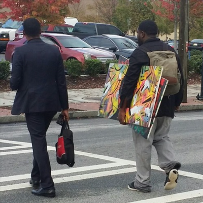 BAIA Talks - Artist Saleam Bey walking with canvases on MLK